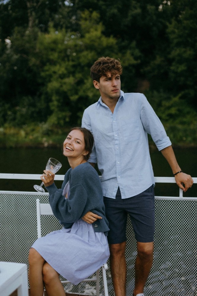 A couple laughing with wine glasses on a boat deck